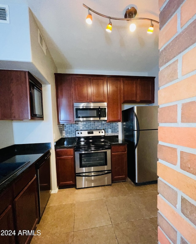 kitchen featuring sink, backsplash, light tile patterned floors, and appliances with stainless steel finishes