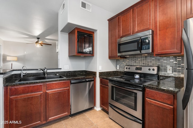 3302 N 7th St Unit 226, Phoenix, AZ 85014 - kitchen with appliances with stainless steel finishes, a ceiling fan, tasteful backsplash, dark stone counters, and light tile patterned flooring
