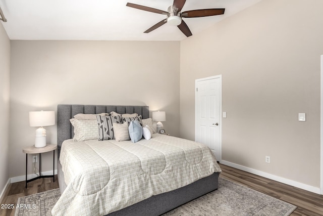 bedroom with a ceiling fan, baseboards, and wood finished floors