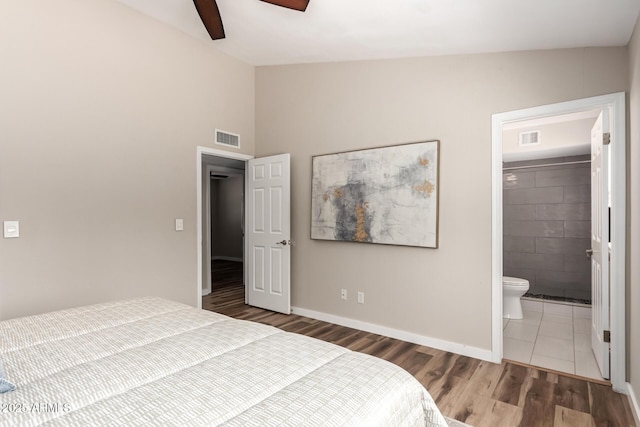 bedroom featuring lofted ceiling, baseboards, visible vents, and wood finished floors