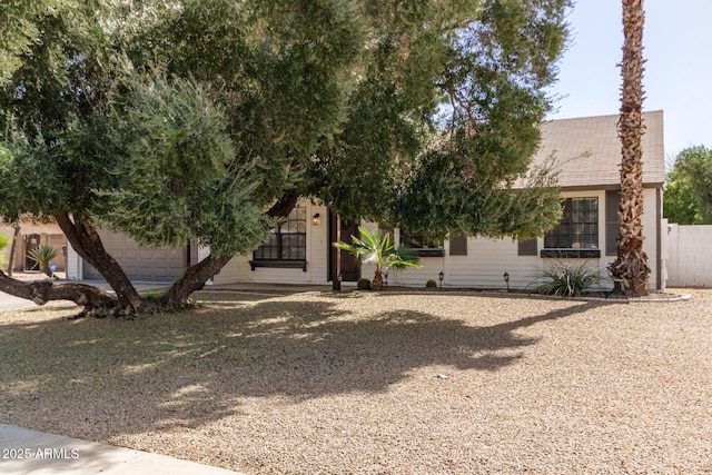 view of front of property featuring a garage and a shingled roof