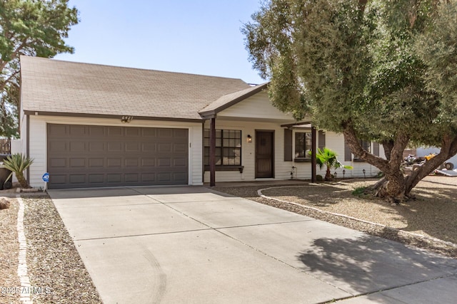 ranch-style home featuring a garage, concrete driveway, and roof with shingles