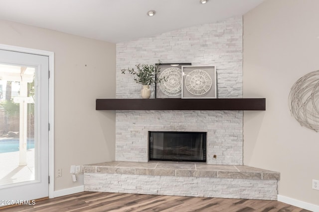 details featuring a fireplace, baseboards, and wood finished floors