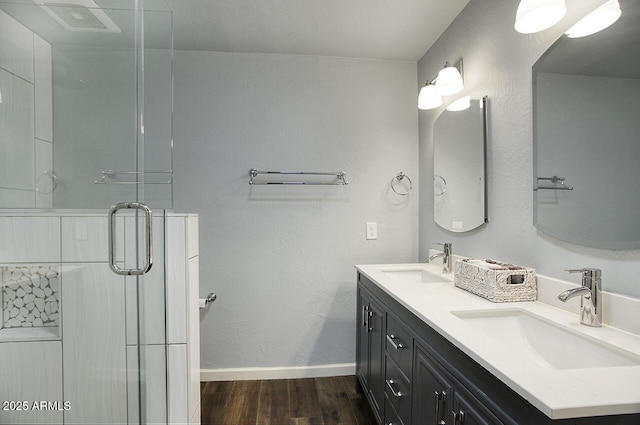 bathroom featuring wood-type flooring, an enclosed shower, and vanity