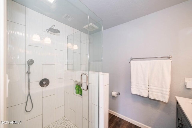 bathroom with hardwood / wood-style flooring, vanity, and an enclosed shower