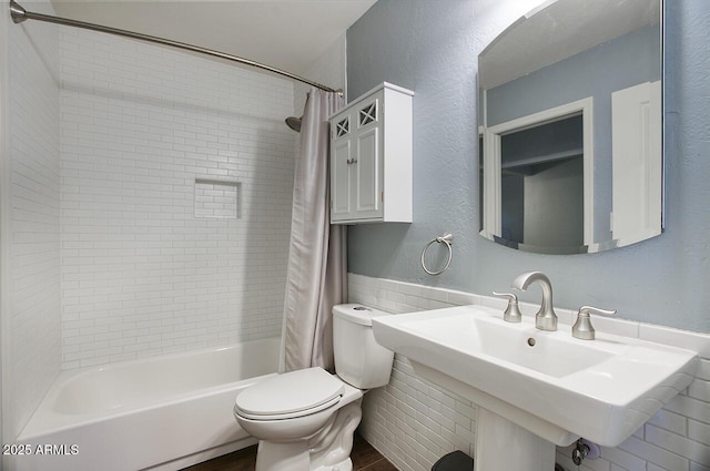 full bathroom featuring sink, toilet, and shower / bath combo with shower curtain