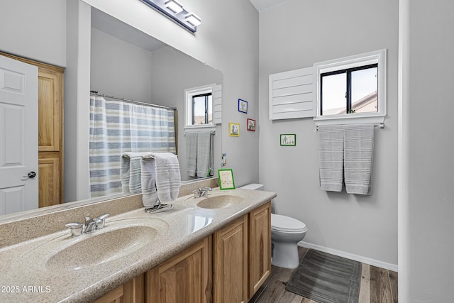 bathroom featuring vanity, hardwood / wood-style flooring, plenty of natural light, and toilet