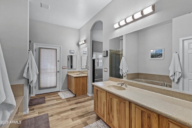 bathroom with vanity, a tub to relax in, and hardwood / wood-style flooring