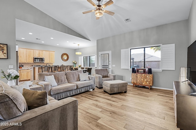 living room featuring high vaulted ceiling, a wealth of natural light, ceiling fan, and light hardwood / wood-style floors