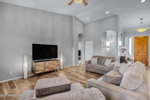 living room featuring ceiling fan, high vaulted ceiling, and light hardwood / wood-style floors