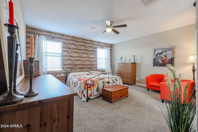 bedroom with carpet floors, ceiling fan, and wood walls