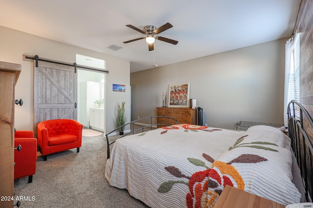 bedroom featuring carpet floors, a barn door, ensuite bathroom, and ceiling fan