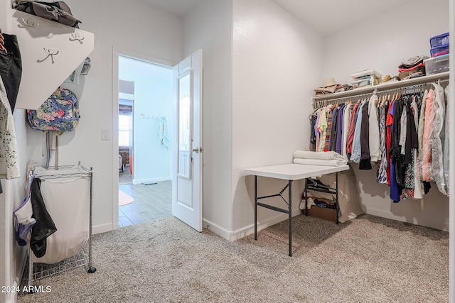 walk in closet with light colored carpet