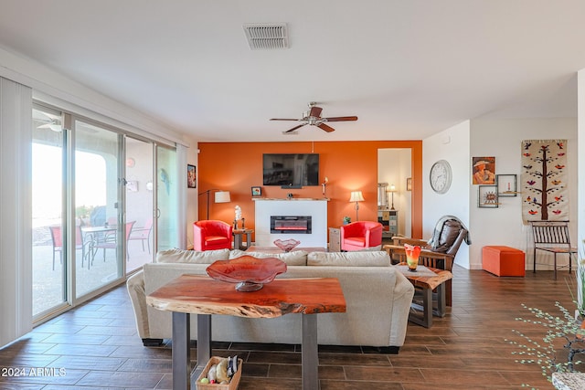 living room with ceiling fan and dark hardwood / wood-style flooring