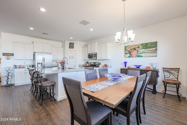 dining room with dark hardwood / wood-style floors, a notable chandelier, and sink