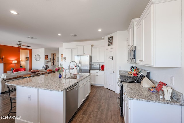 kitchen with dark hardwood / wood-style floors, white cabinetry, a kitchen island with sink, and appliances with stainless steel finishes