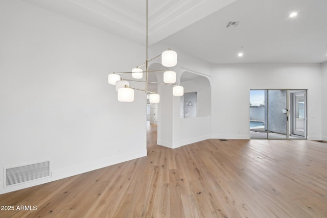 empty room featuring hardwood / wood-style flooring, baseboards, and visible vents