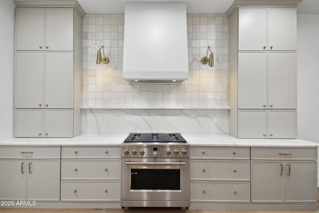 kitchen featuring light stone counters, water heater, backsplash, and high end stainless steel range