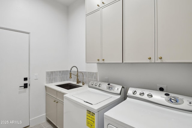 washroom featuring cabinet space, a sink, and washing machine and clothes dryer