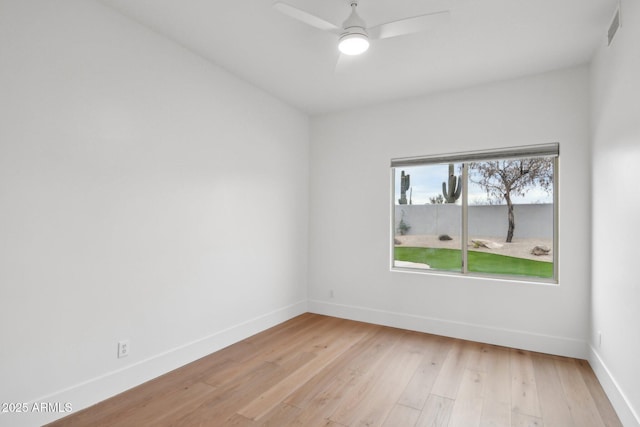 spare room with light wood finished floors, visible vents, baseboards, and ceiling fan