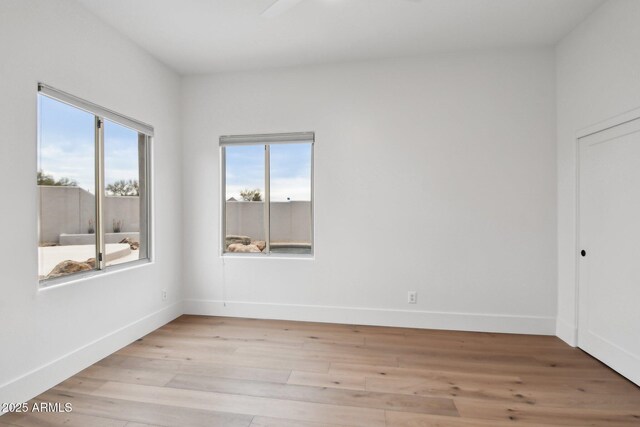 empty room with light wood-type flooring and baseboards