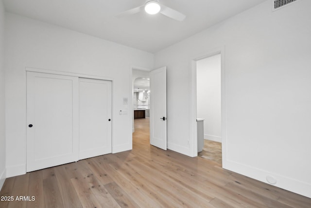 unfurnished bedroom featuring light wood finished floors, a closet, visible vents, and baseboards