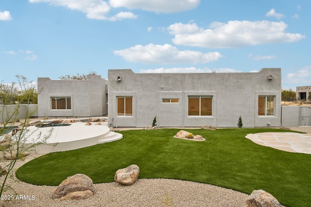 rear view of house with a patio, fence, a lawn, and stucco siding