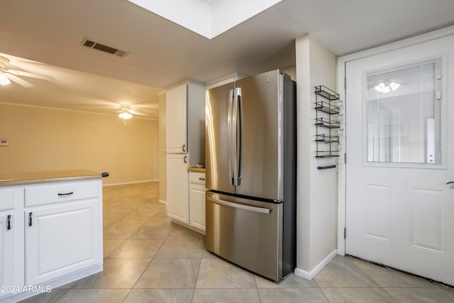 kitchen with white cabinetry, ceiling fan, stainless steel refrigerator, and light tile patterned flooring