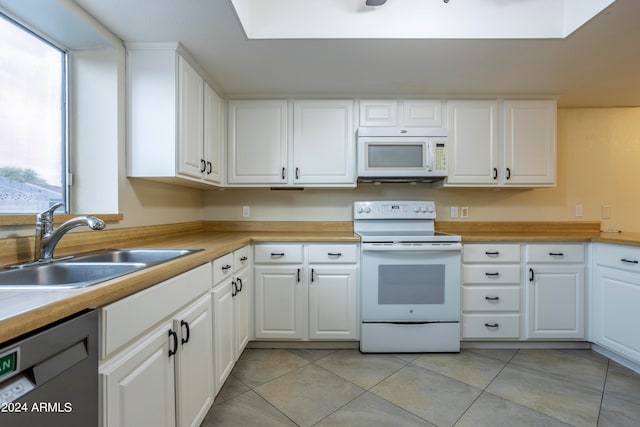 kitchen featuring white appliances, sink, plenty of natural light, and white cabinets