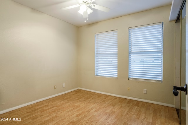 empty room with ceiling fan, a healthy amount of sunlight, and light hardwood / wood-style flooring