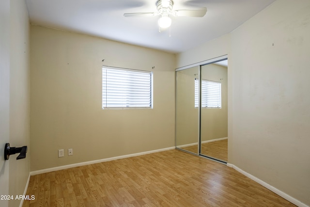 unfurnished bedroom with light hardwood / wood-style floors, a closet, and ceiling fan