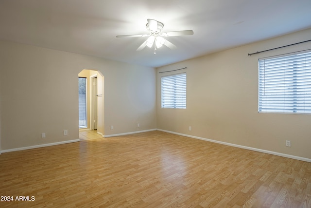 spare room featuring light hardwood / wood-style flooring, a healthy amount of sunlight, and ceiling fan