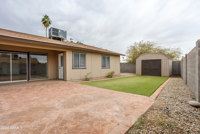 view of yard with a patio, a storage unit, and central AC unit