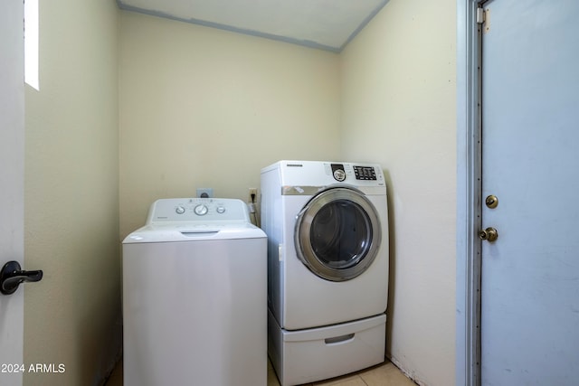 washroom with washing machine and dryer and light tile patterned floors