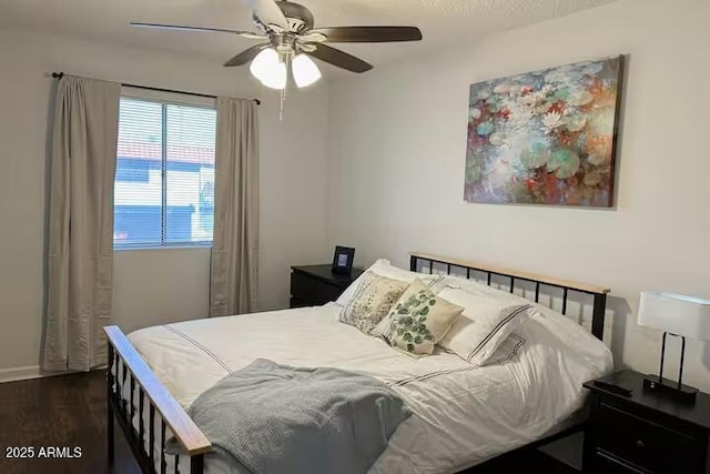 bedroom with dark hardwood / wood-style floors and ceiling fan