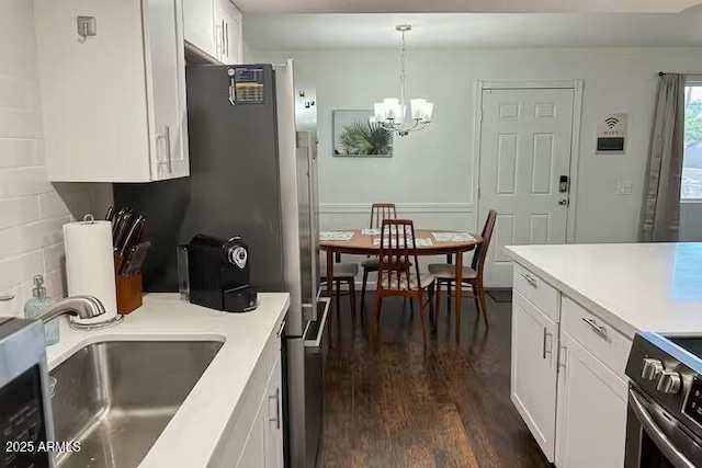 kitchen with sink, white cabinetry, an inviting chandelier, decorative light fixtures, and stainless steel electric range