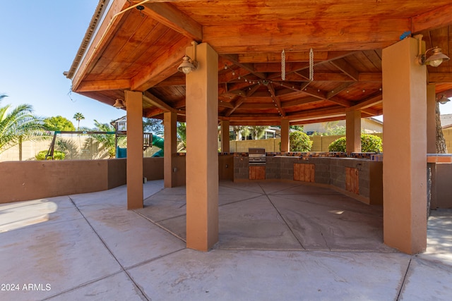 view of patio featuring a gazebo, exterior kitchen, and grilling area