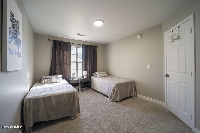 carpeted bedroom featuring baseboards and visible vents