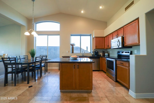 kitchen featuring a sink, visible vents, a center island, dark countertops, and appliances with stainless steel finishes