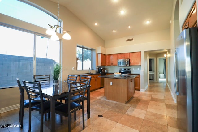 kitchen featuring a sink, stainless steel appliances, visible vents, a center island, and dark countertops