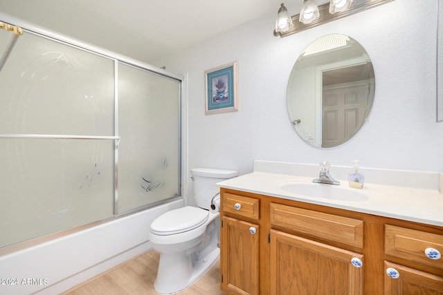 full bathroom with toilet, vanity, combined bath / shower with glass door, and hardwood / wood-style flooring