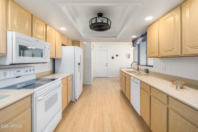 kitchen featuring a raised ceiling, light brown cabinetry, white appliances, and ornamental molding