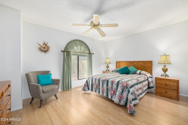 bedroom featuring hardwood / wood-style flooring, ceiling fan, and a textured ceiling