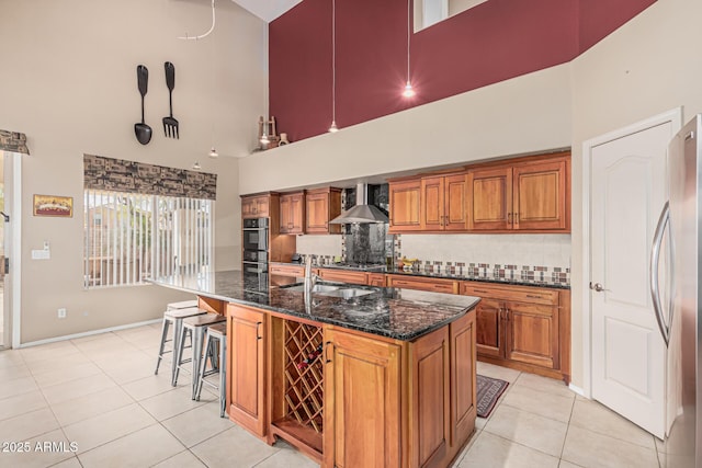 1635 W Windsong Dr, Phoenix, AZ 85045 - kitchen with light tile patterned floors, stainless steel appliances, a sink, brown cabinetry, and wall chimney exhaust hood