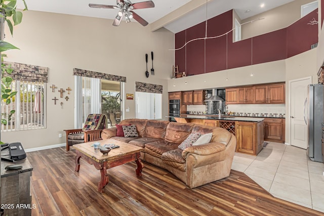 1635 W Windsong Dr, Phoenix, AZ 85045 - living area with baseboards, a towering ceiling, light wood-style flooring, and a ceiling fan