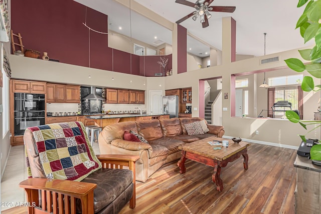 1635 W Windsong Dr, Phoenix, AZ 85045 - living room featuring stairway, light wood-style flooring, baseboards, visible vents, and ceiling fan
