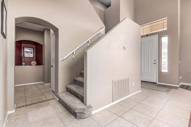 1635 W Windsong Dr, Phoenix, AZ 85045 - interior space featuring stairway, baseboards, a towering ceiling, arched walkways, and visible vents