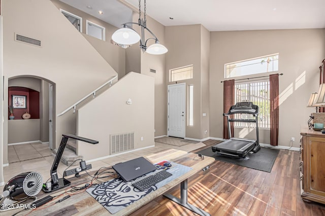 1635 W Windsong Dr, Phoenix, AZ 85045 - exercise room with arched walkways, baseboards, light wood-style flooring, and visible vents
