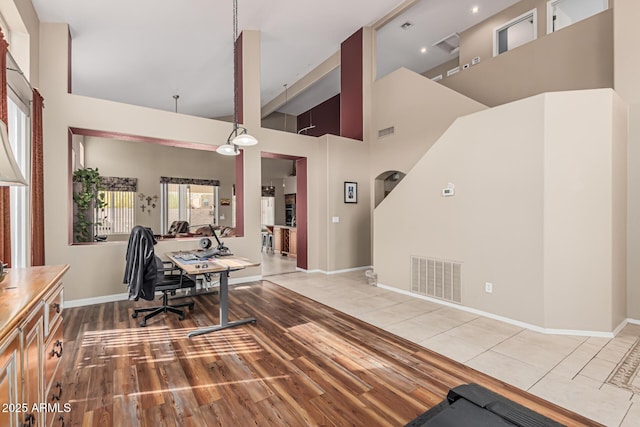 1635 W Windsong Dr, Phoenix, AZ 85045 - office area featuring baseboards, visible vents, wood finished floors, and a towering ceiling