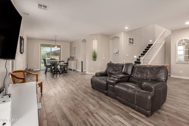 1217 W Fever Tree Ave, San Tan Valley, AZ 85140 - living area featuring wood finished floors, baseboards, stairway, arched walkways, and recessed lighting